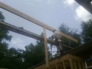 Carpenter setting a ridge beam over a new addition frame — Ice Dam Removal by Roofing Brothers in Elmore City