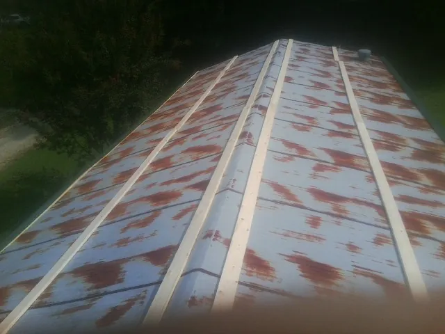 Rusted metal roof panels with new wood purlins before replacement — Storm Damage Roof Repair in Elmore City by Roofing Brothers