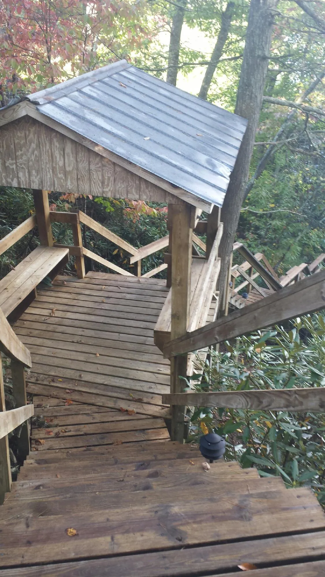 Metal roofed shelter over wooden steps on a wooded walkway — Skylight Repair & Installation work by our crew in Elmore City