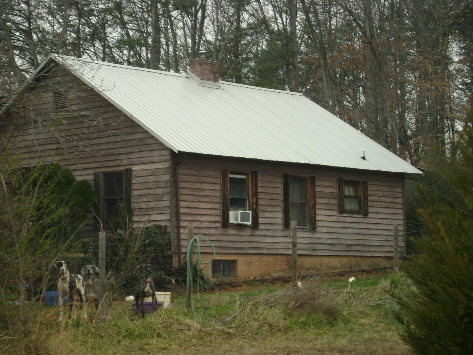 White metal roof on an old wood sided farmhouse, from a Asphalt Shingle Roof Repair job in Elmore City